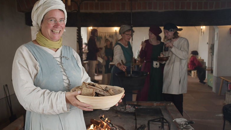 Anja Kiessling vom Team Burgalltag zeigt eine Schüssel mit frisch gebackenem Brot, das sie in Scheiben geschnitten hat. Auch eine deftige Suppe wurde gekocht.