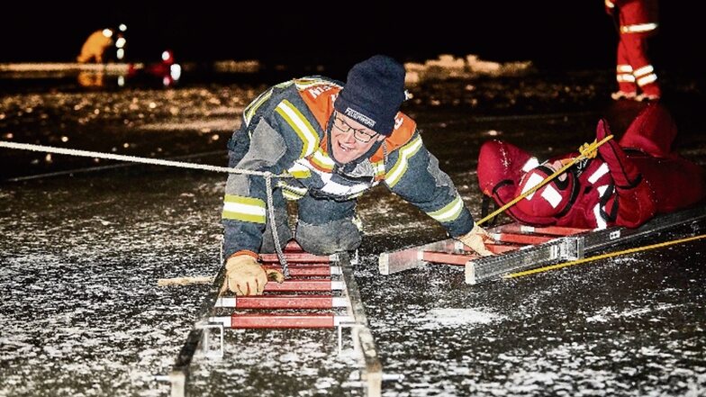 Thomas Münch von der freiwilligen Feuerwehr Königstein holt einen DLRG-Taucher aus dem eisigen Wasser.