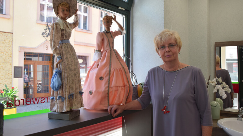 Renate Musiol mit den beiden Puppen, die Kleider im Biedermeier- und im Rokoko-Stil tragen.