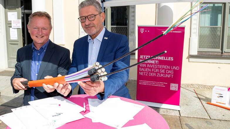 Rainer Frank (links) von der Telekom und Oberbürgermeister Stadt Pirna Klaus-Peter Hanke unterzeichnen eine gemeinsame Absichtserklärung zum Ausbau des Glasfasernetzes.