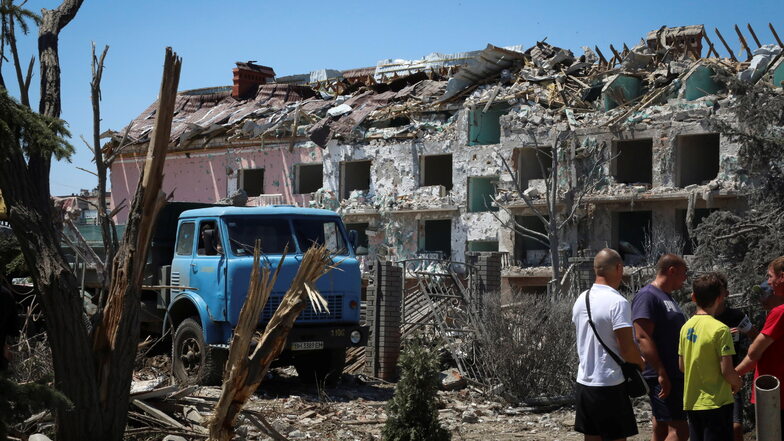 Anwohner stehen neben einem nach dem russischen Raketenangriff beschädigten Wohnhausnahe Odessa. Dort kamen mindestens 21 Menschen ums Leben.