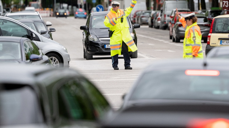 Polizisten regeln auf einer Münchener Kreuzung den Verkehr, nachdem dort die Stromversorgung der Ampeln ausgefallen war.