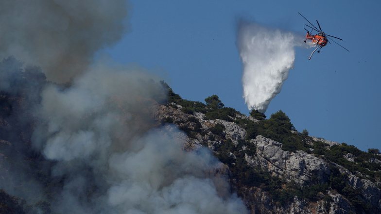 Ein Hubschrauber wirft über einem Feuer in der Nähe des Dorfes Malakasa nördlich von Athen Wasser ab.