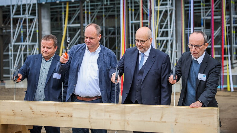 Frank Hübner von Züblin (v.l.), OB Dirk Hilbert, KID-Chef Axel Walther und Jörg Muschol von Dreßler Bau schlagen die Nägel zum Richtfest ein.