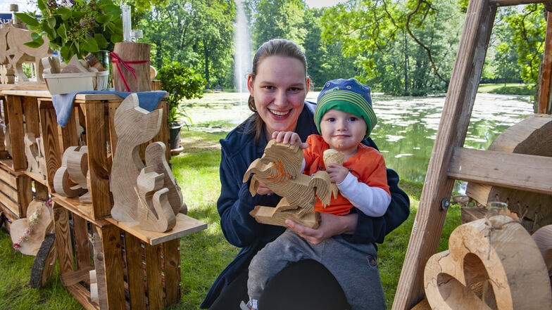 Sandra Langner und Sohn Louis am Holzstand mit den liebevoll gearbeiteten Holzfiguren von Kathrin und Olaf Starke aus Kalkreuth.