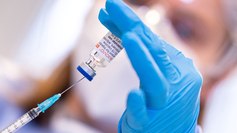 Eine Mitarbeiterin im Impfzentrum hält ein Fläschchen mit dem Impfstoff Nuvaxovid und eine Spritze in den Händen. Große Studien mit mehreren Millionen-Teilnehmern fanden keine Bestätigung für gefährliche Corona-Impfrisiken.