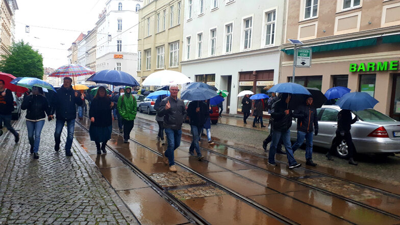 Bei strömendem Regen fand am Montag der Protest-Spaziergang in Görlitz statt, der unter anderem über die Berliner Straße führte. Mittig im Bild ist AfD-Stadtrat Jens Jäschke zu sehen.