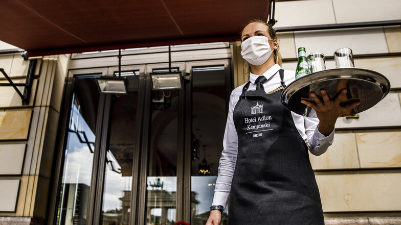 Mitarbeiter in Restaurants und Cafés in Deutschland servieren jetzt mit Mundschutz.