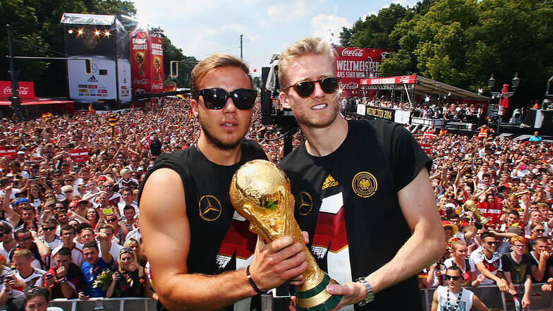 Torschütze Mario Götze (links) und Vorlagengeber André Schürrle feiern mit dem Fußball-WM-Pokal.