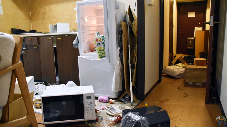 Möbel und Elektrogeräte liegen nach dem Erdbeben verstreut in einer Wohnung.