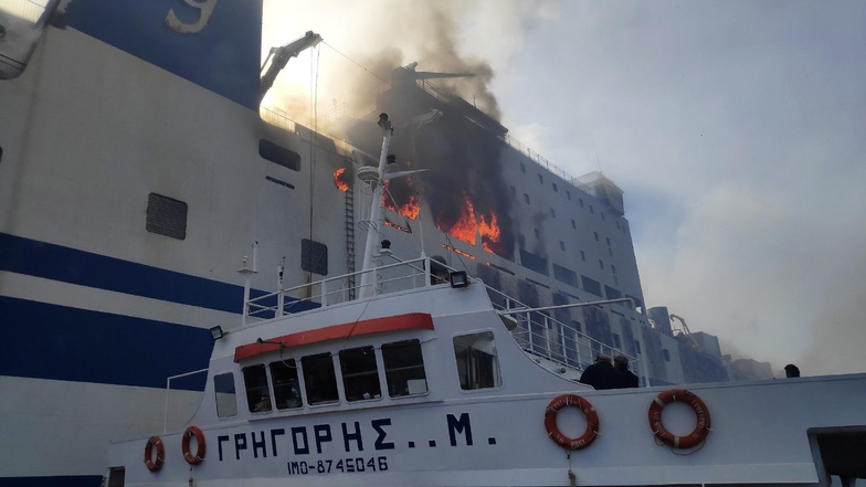 Ein Schiff nähert sich der brennenden Autofähre «Euroferry Olympia» vor Korfu. Einer Spezialeinheit des griechischen Rettungsdienstes ist es gelungen, zwei Männer aus der brennenden Autofähre "Euroferry Olympia" zu retten.