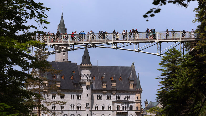Touristen stehen auf der Marienbrücke vor dem Schloss Neuschwanstein. In der Nähe wurden zwei Touristinnen in eine Schlucht gestoßen.