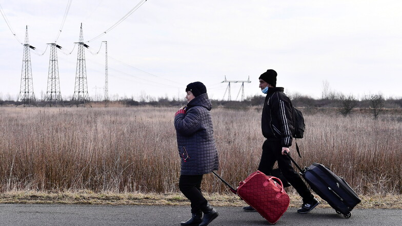 Aus der Ukraine flüchtende Menschen überqueren die ungarisch-ukrainische Grenze.