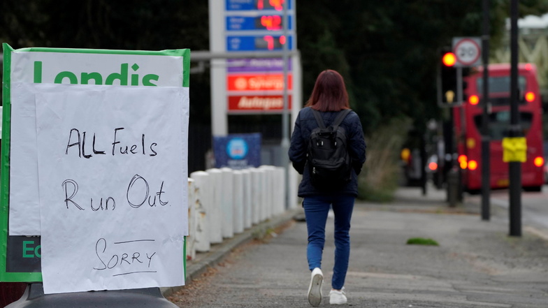 London: Eine Frau geht an einem Schild vorbei, das den Mangel an Kraftstoff am Eingang einer Tankstelle anzeigt.