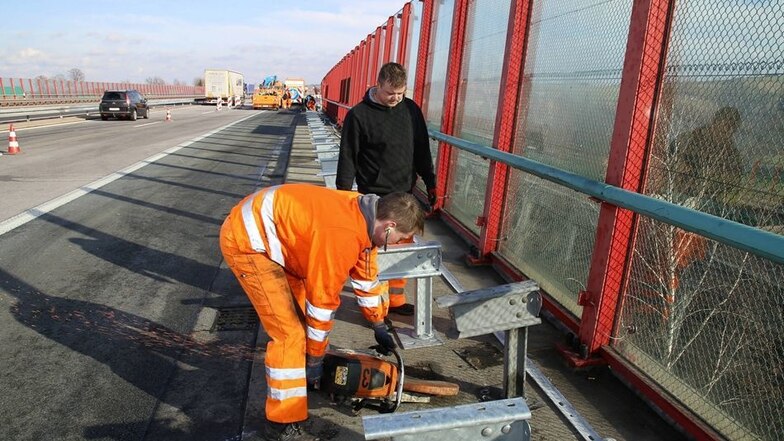 Mitarbeiter des Straßenunterhaltungsdienstes reparieren am Montag die Leitplanken.