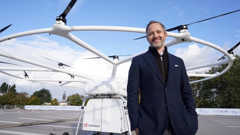 Florian Reuter, Geschäftsführer von Volocopter, steht nach dem Premierenflug im Hafen vor der Schwerlastdrohne Volodrone.