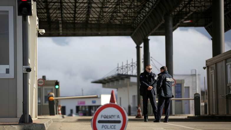 Zwei Polizisten aus dem Kosovo stehen am geschlossenen Grenzübergang zwischen dem Kosovo und Serbien. Kosovo hat den Grenzübergang geschlossen, nachdem serbische Demonstranten in Serbien eine Barrikade errichtet hatten.