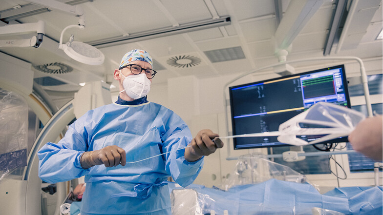 Mit dem Herzkatheter kann diagnostiziert und behandelt werden. Selbst Herzklappen werden so ersetzt. Dr. Felix Woitek vom Herzzentrum Dresden entnimmt ein solches Instrument aus der Verpackung.