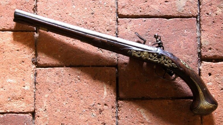 Die Steinschlosspistole – 54 Zentimeter Gesamtlänge – stammt aus der Mitte des 18. Jahrhunderts und wurde in Wien von Martin Ovaleci hergestellt. Sie weist einige Gravuren auf.