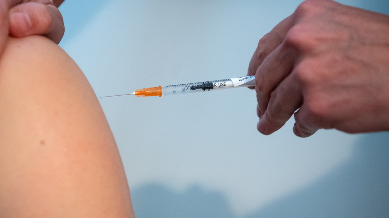 Eine Ärztin impft einen Mann gegen das Coronavirus. Auch die Sächsische Impfkommission empfiehlt jetzt eine weitere Auffrischungsimpfung für alle Menschen ab 60 Jahren.