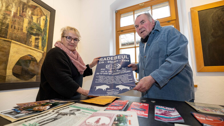 Cornelia Bielig und Herbert Graedtke stehen an einem Tisch mit vielen Erinnerungsstücken an die Anfänge der Karl-May-Festtage, darunter ein Plakat von der ersten Ausgabe 1992. Beide haben das Fest initiiert und sind dessen Gründungsmutter und -vater.