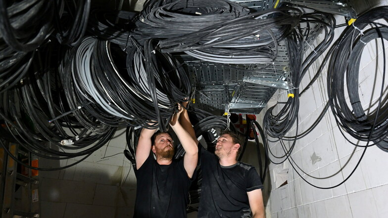 Klaus Pletl (links) und Sebastian Kerscher sortieren und bündeln die Kabel in der künftigen Zentrale der Veranstaltungstechnik.