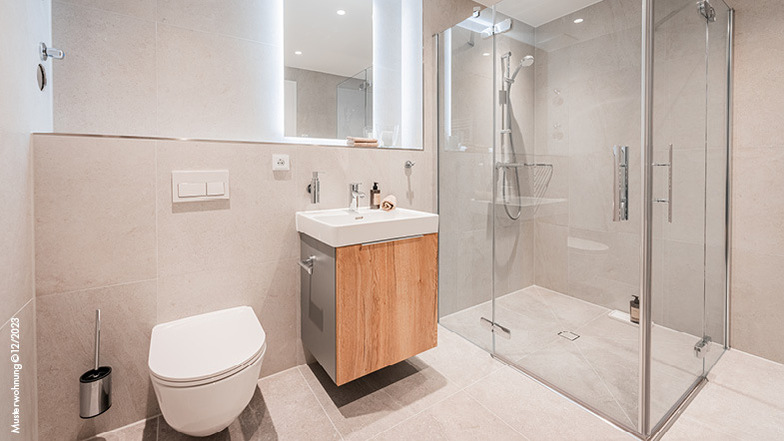 Die Badezimmer sind mit raumhohen Fliesen (60 x 60 cm) verkleidet und mit eleganten Sanitärarmaturen von renommierten Marken wie Grohe und Laufen ausgestattet.