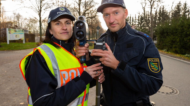 Finger am Abzug: Die Polizeibeamten Heidi Pillat und Philip Heymann mit ihrer Laserpistole auf Posten vor dem Birkwitzer Kindergarten.