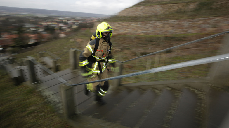 Als sei es nicht schon in Sportsachen anstrengend genug, stellen sich Feuerwehrleute um den Coswiger Ben Hirrich einer besonders großen Herausforderung und erklimmen die Spitzhaustreppe in voller Einsatzausrüstung.
