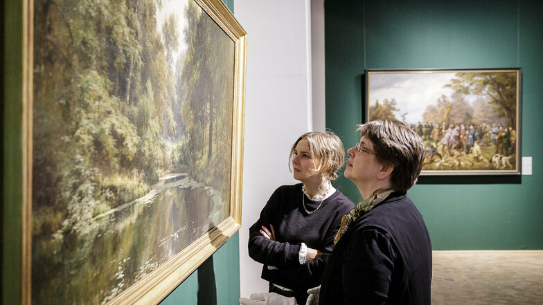 Eindrucksvolle Landschaften haben Kuratorin Johanna Brade (r.) und Volontärin Romy Czimmernings für den ersten Raum der Ausstellung ausgewählt, hier "Waldfrieden" von Adolf Dressler.