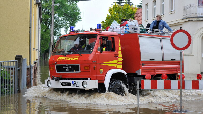 Die Döbelner Feuerwehr bringt am 3. Juni 2013 auf der überfluteten Teichstraße in Döbeln Anwohner aus der Gefahrenzone.