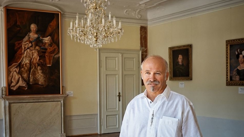 Roland Schwenke im Gartensaal des Schlosses vor seinen Bildern.