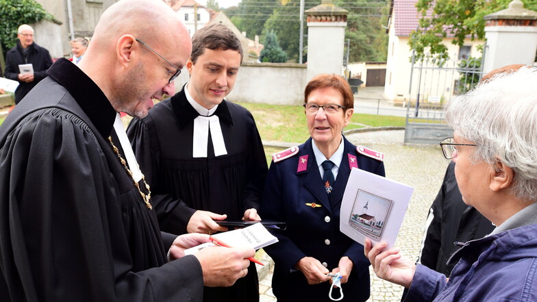 Landesbischof Tobias Bilz gab nach dem Gottesdienst noch Autogramme, auch für Christine Engemann von der Freiwilligen Feuerwehr.