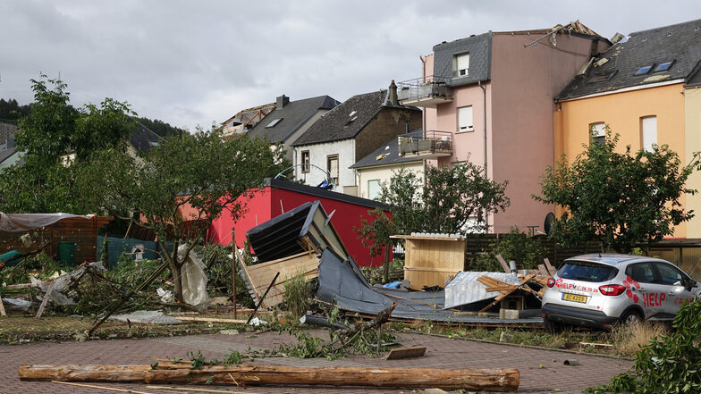Luxemburg, Petingen: Nach einem schweren Unwetter mit einem Tornado liegen Trümmer auf einem Platz.