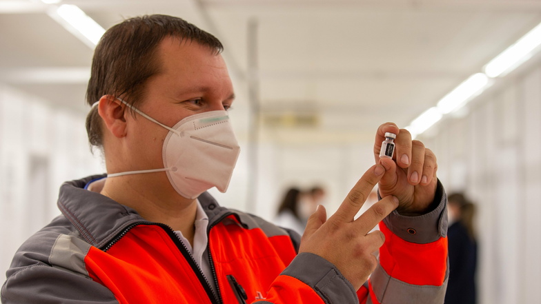 Christian Thie, Leiter des Impfzentrums in Pirna-Jessen, hält ein leeres Fläschchen des Corona-Impfstoffs in der Hand.