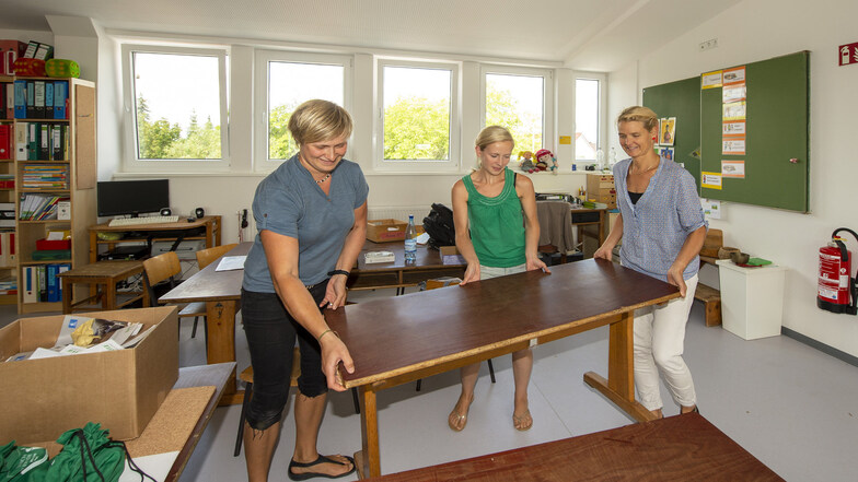 Die Klassenleiterinnen Jule (l.) und Simone (r.) räumen mit Referendarin Laureen eines der neuen Klassenzimmer im Dachgeschoss ein.