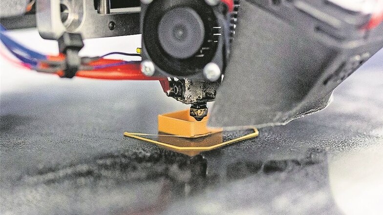 Der Drucker trägt den geschmolzenen Kunststofffaden auf das Druckbett auf.