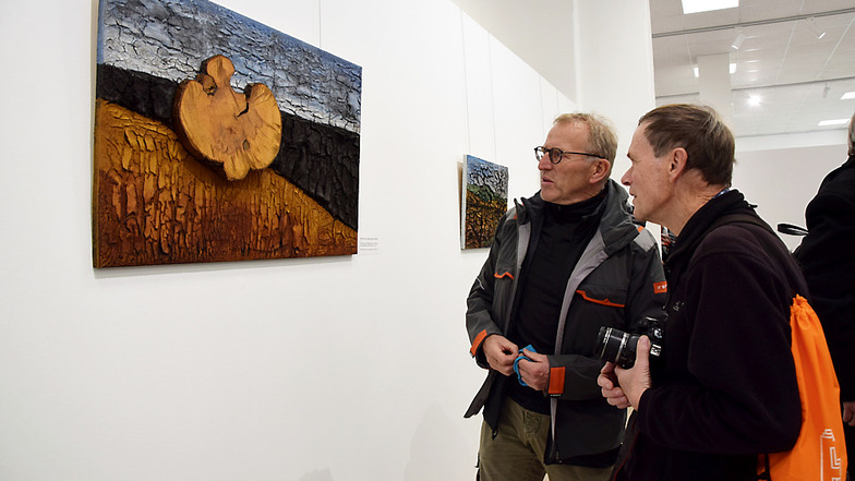 Prof. Dr.-Ing. Bernhard Glück (links) zeigt Herbert Schnabel eine Collage, die er aus im Moor gefundenen Materialien geschaffen hat.