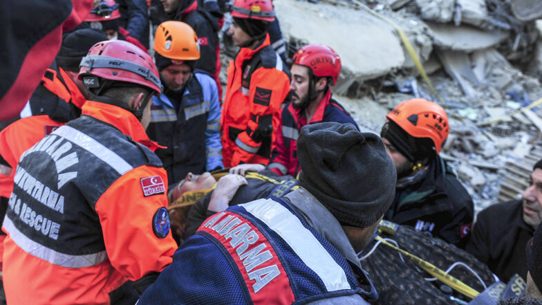Rettungskräfte transportieren eine verletzte Frau ab, die sie nach einem starken Erdbeben aus den Trümmern eines eingestürzten Gebäudes gerettet haben. 