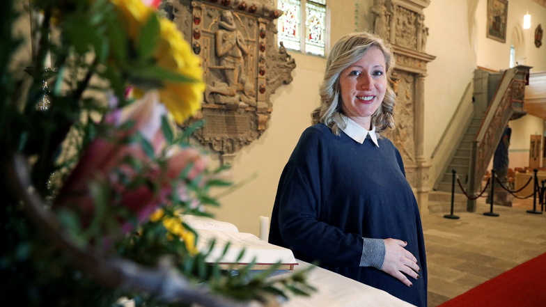 Pfarrerin Claudia Friedrich steht am Altar in ihrer neuen Wirkungsstätte in der Kirche Strehla. Behutsam streichelt sie ihren Bauch.