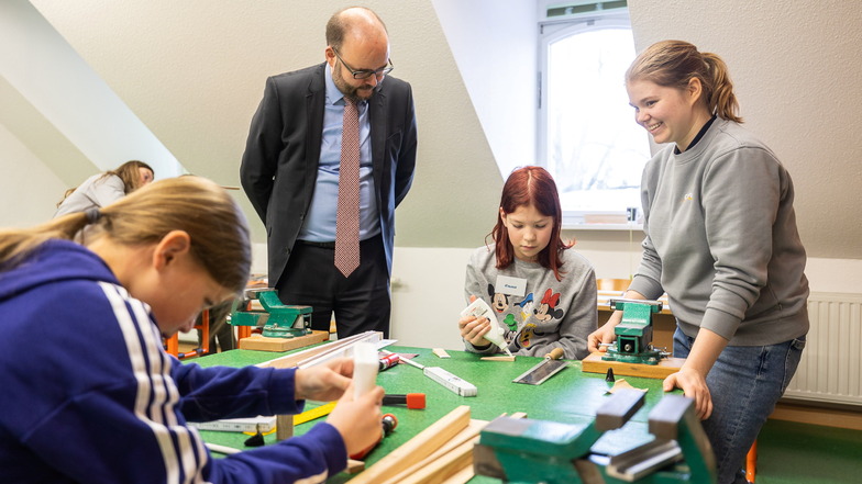 Der Minister schaut zu: Christian Piwarz (CDU) am Montag zu Besuch in der Grundschule Lauenstein, wo Emma und Melanie Kaiser an einer Grillzange basteln.