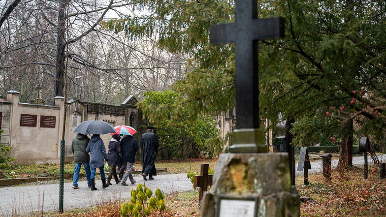 Ein Mitarbeiter des Friedhofs, ein Pfarrer und Besucher der Beisetzung auf dem Weg zur letzten Ruhestätte auf dem Alten Friedhof der Stadt Görlitz.