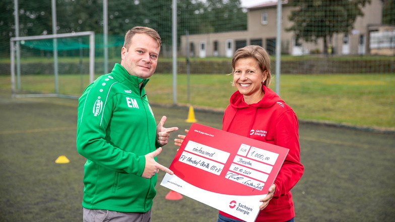 Constance Jacob von Sachsen-Energie überreicht einen 1.000 Euro-Scheck an Eric Mantke vom Fußballverein Ottendorf-Okrilla 05.