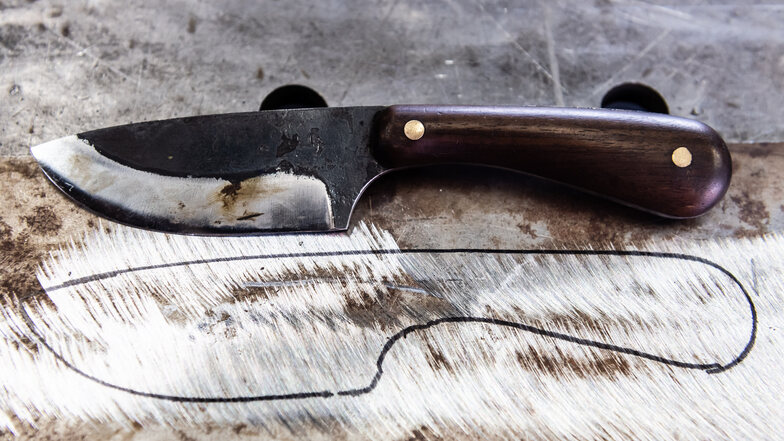 Die Kontur des Messers wird auf einer Schablone aus Stahlblech vorgezeichnet.