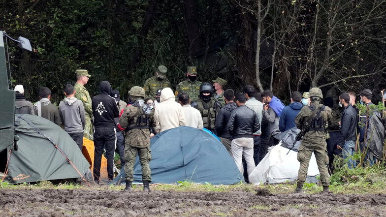 Migranten, die an der Grenze zu Belarus festsitzen, werden von polnischen Beamten umstellt. Polens Grenzschützer haben im August an der Grenze zu Belarus rund 3.500 Versuche einer illegalen Einreise registriert.