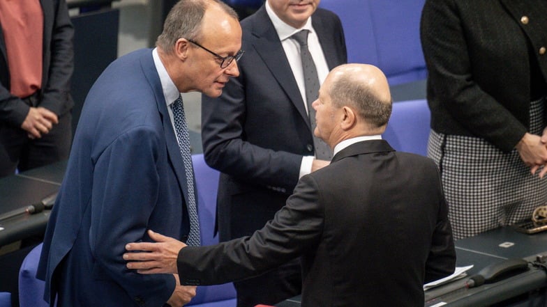 Bundeskanzler Olaf Scholz (r, SPD) spricht mit Friedrich Merz, CDU-Bundesvorsitzender. Scholz bietet der Union Zusammenarbeit bei Migration an.