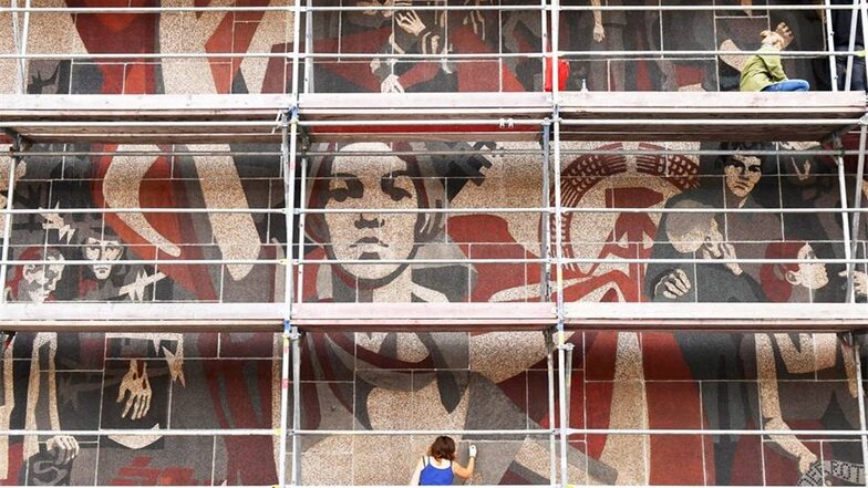 Studenten arbeiten am Wandbild "Der Weg der roten Fahne", das sich an der Westfassade am Kulturpalast Dresden befindet.