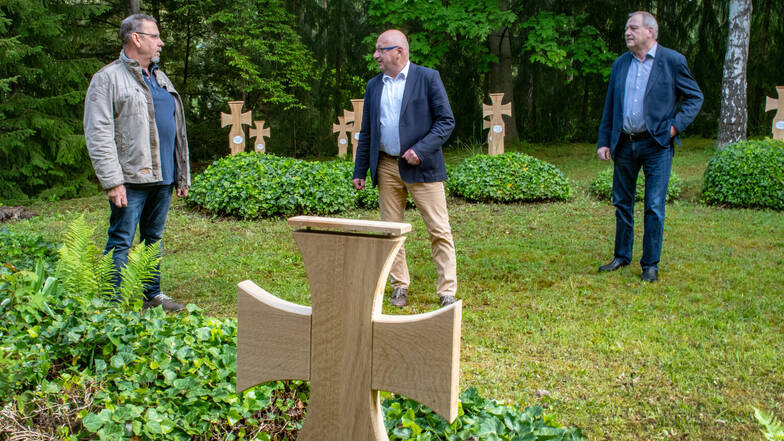 Gunter Zetzsche, Schatzmeister des Heimatvereins, Bürgermeister Steffen Ernst und Albrecht Hänel, Vorsitzender des Heimatvereins (von links), zeigen die neu gestalteten Gräber für die Gefallenen des Zweiten Weltkriegs auf dem Waldheimer Friedhof.
