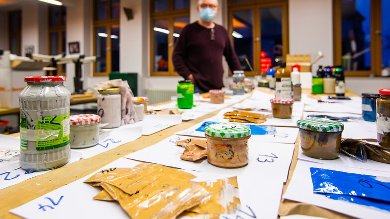 Jens-Uwe Röhl am Tisch, auf dem die benötigten Farben für die Leinwände vorsortiert und beschriftet sind. In der Kreativwerkstatt ist alles deponiert, was der Kartoffeldrucker so braucht. Hier ist die Ausgabe der nötigen Materialien – nur die Karto
