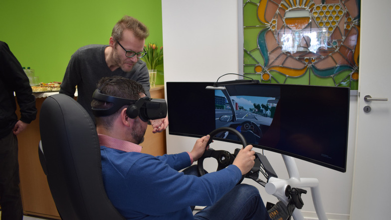 Konstantin Kohl (l.) hilft bei der Einrichtung der VR-Brille zur Nutzung des Fahrschul-Simulators. Er ist mit der Software-Entwicklung der Geräte betraut.